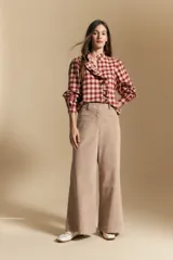 Pantalón de pana de tiro alto con silueta amplia wide leg, cintura definida con botones frontales y bolsillos laterales.