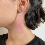 Par de aros colgantes con forma de serpiente plateada con detalles en negro.