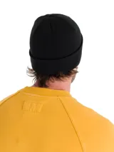 Gorro tipo beanie de punto acanalado en color negro, con puño enrollado y etiqueta pequeña con el logo de la marca Caterpillar en amarillo.