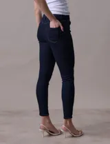 Jean skinny de tiro alto, color azul oscuro, con pretina con pasadores, botón y cierre.