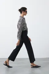 Pantalón de mujer color beige, de corte recto y tiro alto, con costuras frontales marcadas que recorren la pierna.