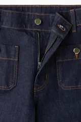 Pantalón de jean azul oscuro, de tiro alto, corte ancho y largo tobillero. Presenta bolsillos delanteros con botón y bolsillos traseros abiertos.