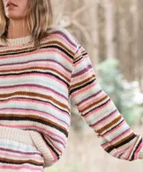 Sweater tejido a mano en lana merino, con diseño de rayas horizontales en tonos blancos, marrones, rosados y celestes, de corte cómodo, cuello redondo base y mangas largas.