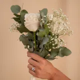 Anillo solitario de oro blanco 18k con una piedra central de aguamarina en corte ovalado y pequeños brillantes laterales engarzados en cuatro puntas.