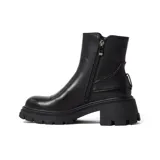 Bota corta marrón oscuro de cuero, con cierre lateral y hebilla decorativa en el tobillo. Tiene suela track y taco bajo.