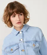 Campera cropped de jean celeste con escote solapa, manga larga, bolsillos delanteros y elástico en el bajo.