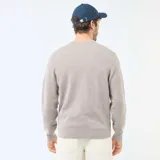 Cárdigan de punto color beige con cuello en V, cierre frontal con botones y dos bolsillos delanteros. Presenta puños y ruedo acanalados.