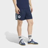 Short de fútbol Adidas de la colección Alemania Originals, color azul marino con diseño de rayas verticales sutiles. Presenta las tres tiras características de la marca en los laterales en color celeste y el escudo de la selección alemana en el muslo derecho.