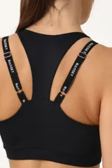 Top deportivo negro con espalda cruzada, elástico inferior y tiras regulables con logo Basset.