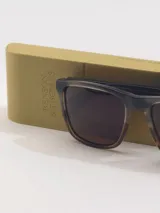 Lentes de sol Benson&Thomas modelo Rosso, con armazón de acetato en tonos verde y tostado, y cristales marrones.
