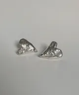 Par de aros plateados con forma de corazón irregular y diseño escultórico.