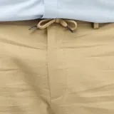 Pantalón recto de lino mixto color beige, con bolsillos laterales y traseros, ideal para un look casual y fresco.