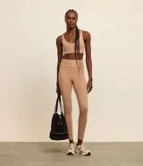 Calza deportiva color beige con costuras a la vista.