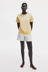 Remera de corte recto en punto suave de algodón, color amarillo, con cuello redondo ribeteado y hombros ligeramente caídos.