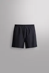Pantalón corto deportivo de Zara Athleticz confeccionado en tejido técnico ligero y elástico de color negro. Cuenta con cintura elástica ajustable con cordón, bolsillos frontales y aberturas laterales en el bajo.