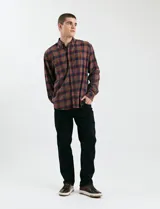 Camisa de franela a cuadros con cuello button-down, manga larga y botones de madera. Presenta dos bolsillos tipo parche en el frente con cierre de botón.