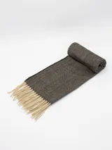 Bufanda tejida con diseño de espiga en tonos marrones y negros, con flecos largos en color beige en los extremos.