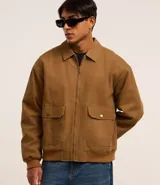 Campera bomber marrón de sarga de algodón, con cuello inglés, cierre frontal con cremallera, bolsillos cargo con botón y puños y cintura ajustados.