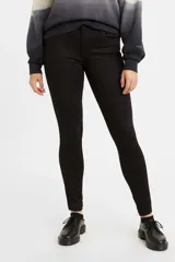 Jean de corte super skinny, tiro medio y color negro sólido. Presenta un diseño clásico de cinco bolsillos con cierre de cremallera y botón metálico.