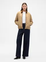 Campera puffer acolchada con diseño de rombos, color beige, con cuello de pana en tono marrón y puños elásticos.