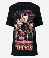 Remera negra de algodón con cuello redondo y manga corta. Presenta un estampado gráfico grande de los personajes principales de la serie Stranger Things, con el texto "One Last Strange Adventure" en la parte superior.