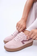 Championes urbanos de diseño minimalista, color blanco con detalles en verde oliva en los laterales y suela de goma color caramelo.