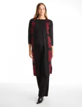 Chaleco largo tejido de la marca Tahari, con diseño tribal en color rojo sobre fondo negro. Presenta un corte recto y abierto al frente.