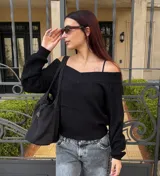 Sweater de punto color negro, con escote estilo bardot y mangas largas. Presenta un diseño acanalado y corte ajustado.