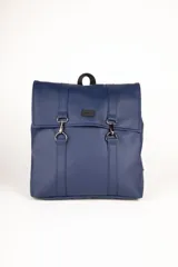 Mochila desplegable de símil cuero azul marino, con solapa frontal asegurada por tiras con hebillas metálicas en forma de 'D' y mosquetones. Posee un asa superior y correas ajustables.