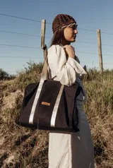 Bolso tipo tote bag negro con detalles dorados en las asas y en el logo.