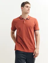 Remera polo azul marino con ribetes blancos en el cuello y en los bordes de las mangas corta, y cierre frontal de botones.