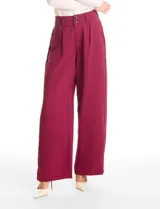 Pantalón tipo palazzo de corte ancho y fluido, confeccionado en tejido sastrero. Presenta tiro alto con doble abotonadura frontal, pinzas decorativas y cintura elástica en la parte posterior. Incluye bolsillos laterales funcionales.