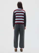 Polera de punto con diseño de rayas horizontales en tonos celeste y bordó en el cuerpo, y mangas a rayas en tonos gris y negro. Presenta cuello redondo y detalle de bordado en el pecho.