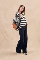 Sweater de punto a rayas horizontales anchas en color negro y crudo, de corte oversize, mangas largas y cuello redondo.