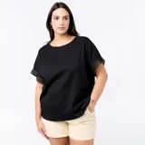 Remera negra de corte holgado y escote redondo, de manga corta con detalles de bordado y encaje macramé en las mangas.