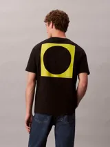 Remera de algodón negro Calvin Klein con cuello redondo, manga corta y logotipo estampado en amarillo alineado en la parte derecha del pecho.