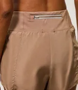 Short runner deportivo 2x1 de microfibra color bordó, con cintura elástica, bolsillo funcional con cierre y bajo redondeado.