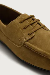 Zapato estilo náutico fabricado en piel con acabado serraje, con detalle de bordón en el empeine, horma redonda y suela ultrafina a contraste.
