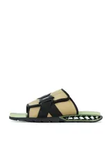 Sandalias tipo slide color beige con detalles en negro y suela verde.