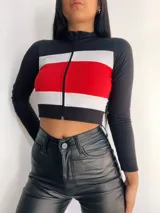 Top manga larga con cierre frontal y diseño tricolor con franjas horizontales en negro, blanco y rojo, fucsia, violeta o azul.