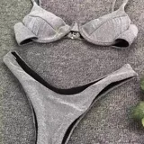 Conjunto de bikini plateado brillante, con corpiño con aros y bombacha tipo tanga.