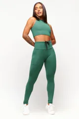 Calza deportiva roja de tiro alto con cordón ajustable en la cintura y logo estampado en la pierna.