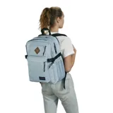 Mochila JanSport modelo Main Campus en color celeste. Cuenta con dos compartimentos principales con cierre, un bolsillo frontal con cierre, correas de compresión laterales con hebillas y un bolsillo lateral de malla para botella. Incluye un parche decorativo en el frente y el logo de la marca en la parte inferior.