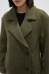 Chaqueta de corte holgado en color negro, con cuello solapa, cierre frontal con botones y bolsillos laterales.