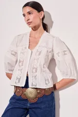 Blusa negra de algodón peinado con calce oversize, escote en V, mangas tres cuartos abullonadas y detalles de encaje y bordados en el frente y mangas.