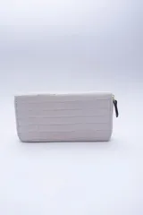 Billetera rectangular con cierre perimetral, confeccionada en cuero con textura de reptil. Cuenta con múltiples compartimentos internos para tarjetas, documentos y billetes, además de un bolsillo interior con cierre para monedas.