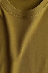 Remera oversized de algodón color verde militar, con cuello redondo ribeteado y hombros levemente caídos.