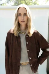 Cardigan de punto color marrón, abierto con botones imitación hueso, manga larga con parche bordado y diseño texturado.