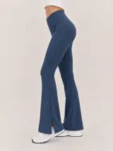 Calza deportiva de tiro alto color azul marino, de alta compresión y diseño acampanado con pequeña abertura en el dobladillo inferior.