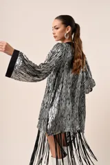 Kimono corto con estampado de rayas plateadas y negras, mangas campana con puños negros y flecos negros en el dobladillo.